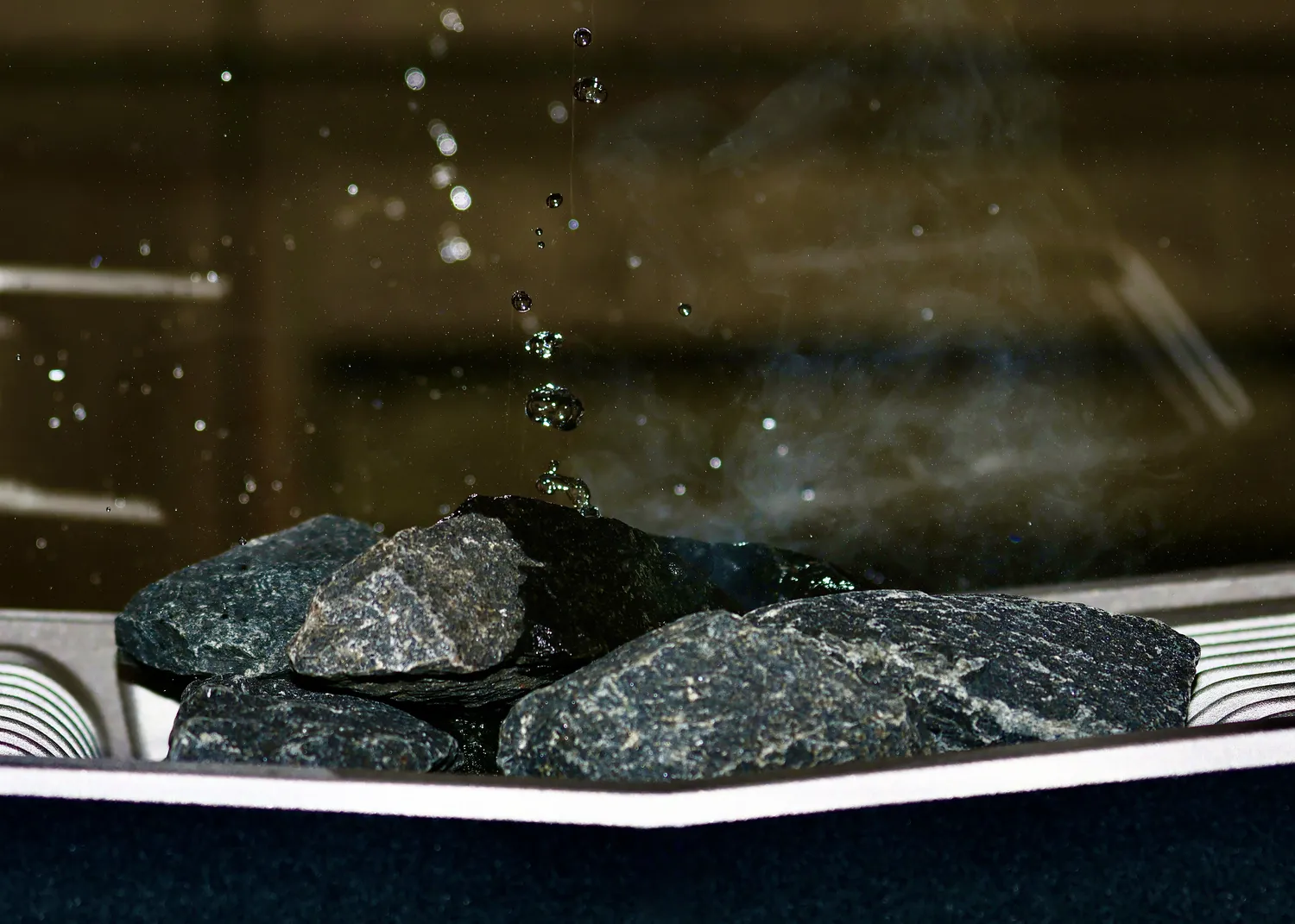 Sauna Stegmann - Wellness & More - Wasser trifft auf heiße Steine und Dampf steigt auf