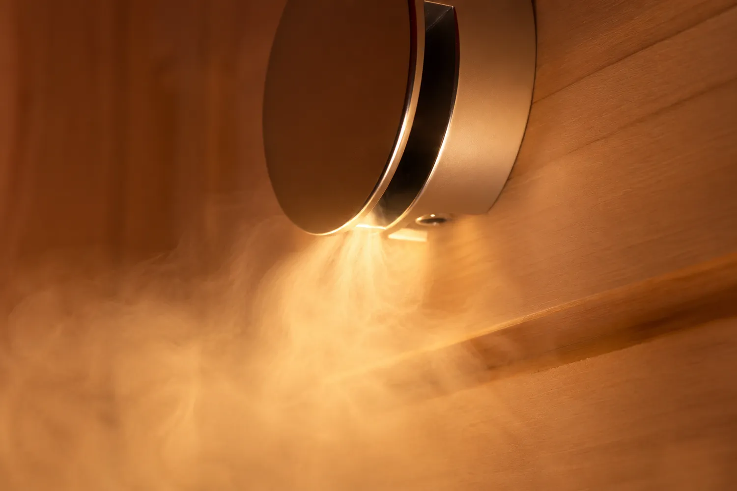 Sauna Stegmann - Wellness & More - Saunalampe mit warmem Licht und Dampf an der Holzwand